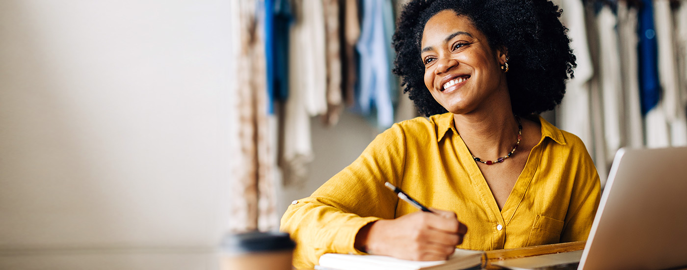Smiling young woman using laptop at work.